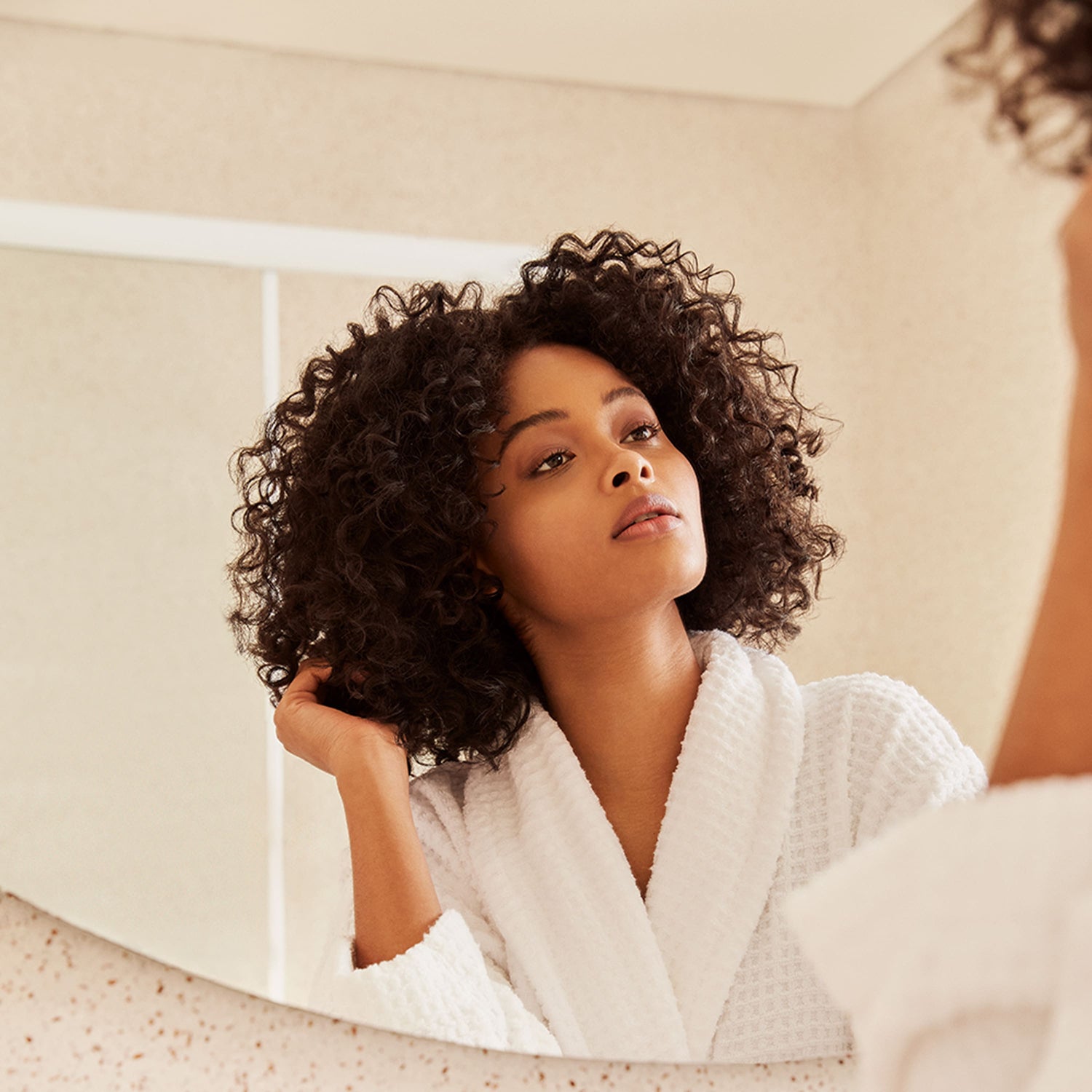 The Power of Pre-Pooing: Preparing Your Curls for Washing Girl looking at the mirror playing with her hair
