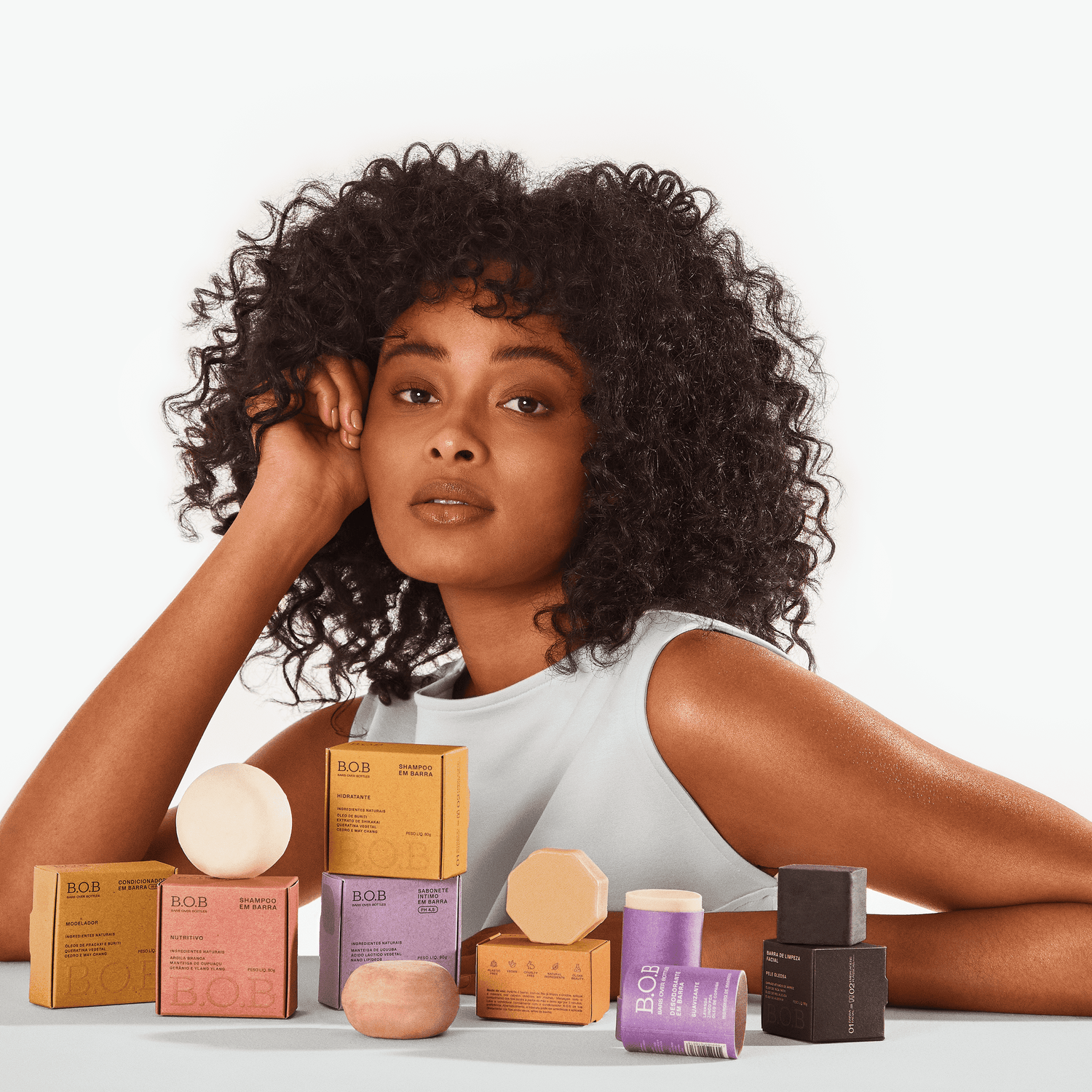 Ingredients to Avoid in Shampoos for Curly Hair Girl standing next to Bars Over Bottles products