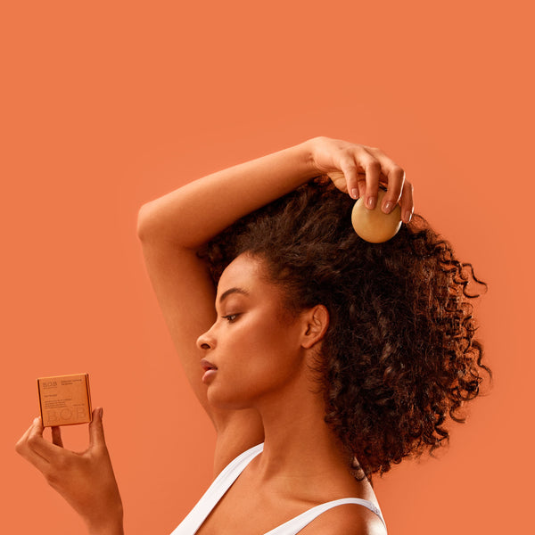 Curly Girl holding the Moisturizing Shampoo Bar