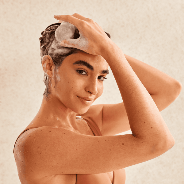 Girl applying shampoo bar on her hair