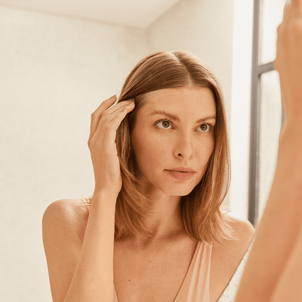 Girl checking her hair on the mirror