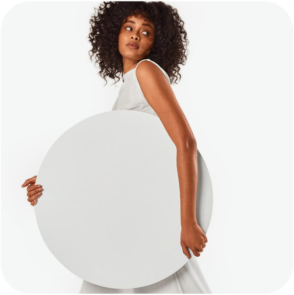 Elegant woman holding a big round white thick paper symbolizing Bars Over Bottles oily hair conditioner